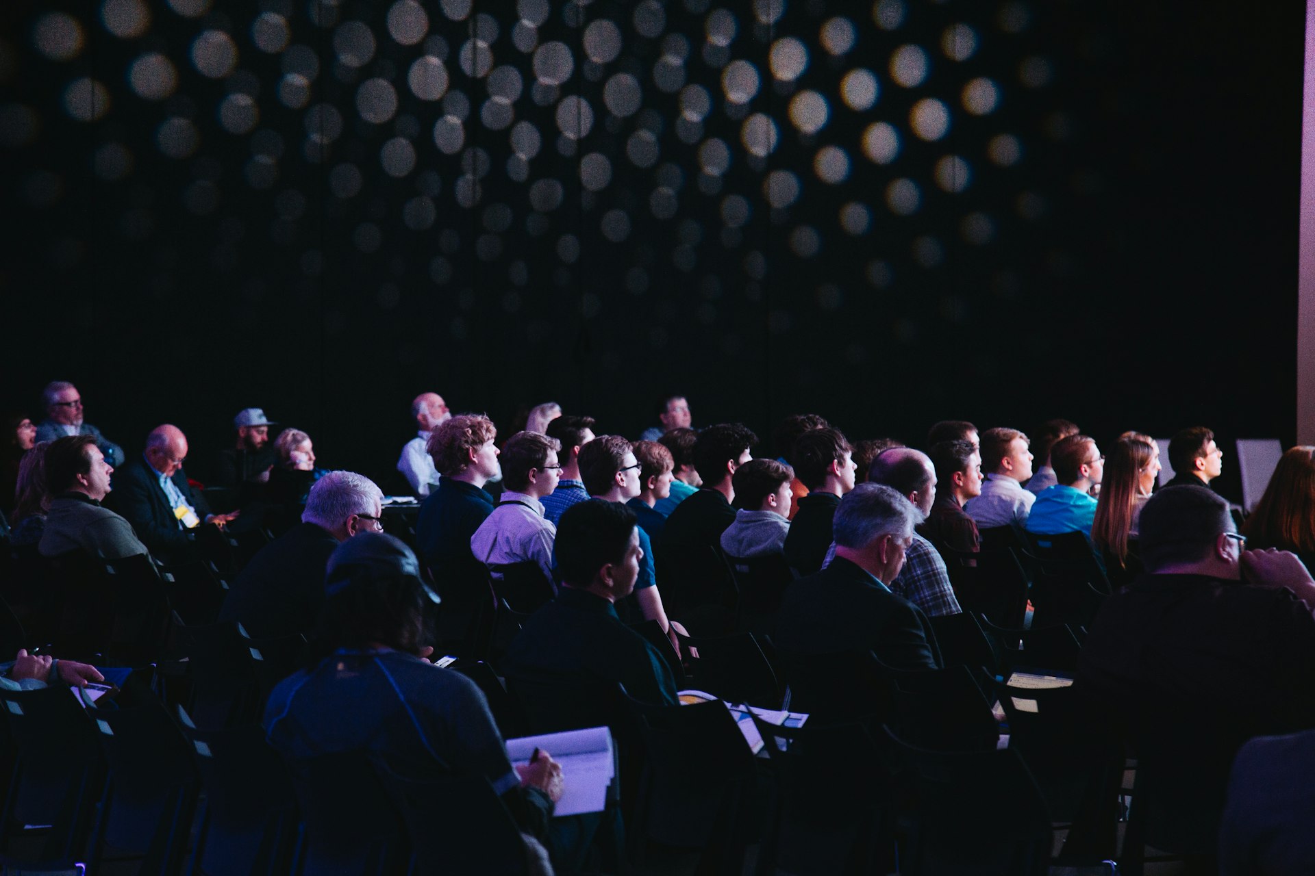 Conference audience seated in a darkened auditorium