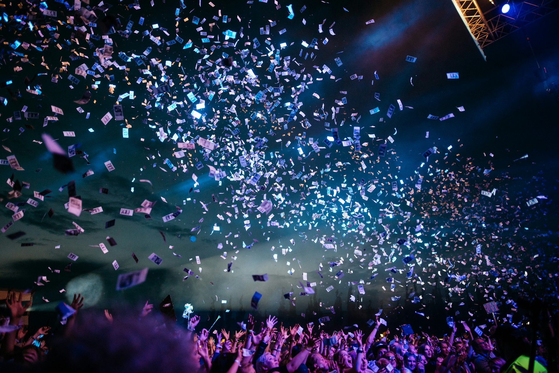Festival crowd at night beneath falling confetti